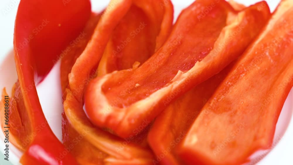 A white plate with chopped red bell peppers spins on the turntable. Close-up. View from above A white plate with chopped red bell peppers spins on the turntable. Close-up. View from above