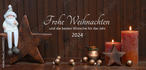 Weihnachtskarte mit deutschem Text Frohe Weihnachten und die besten Wünsche für das Jahr 2024. Weihnachtsdekoration mit Stern, Weihnachtsmann und brennenden Kerzen vor Holzhintergrund. photo