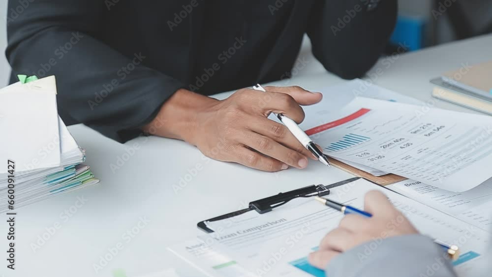 Group of confident business people point to graphs and charts to analyze market data, balance sheet, account, net profit to plan new sales strategies to increase production capacity. Group of confident business people point to graphs and charts to analyze market data, balance sheet, account, net profit to plan new sales strategies to increase production capacity.