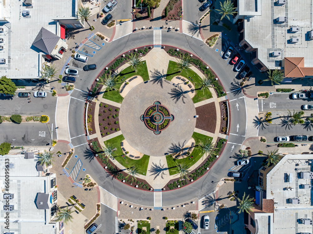 Aerial photo of a roundabout in a shopping center in Brentwood, California with palm trees, foundation and cars