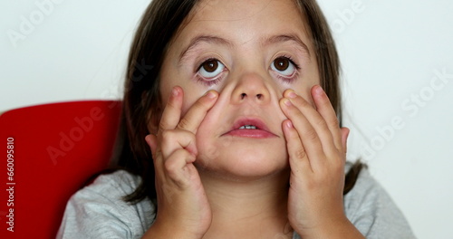 Little girl grimacing, sticking ongue out. Child grimace making funny faces photo