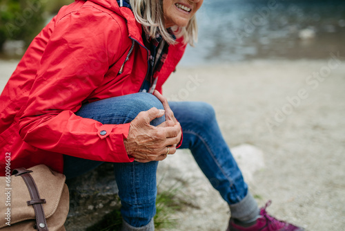 Canvas Print Senior woman injured leg during hike in the mountains