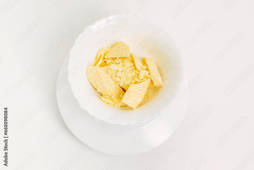 There are pieces of cocoa butter in a white plate. There are pieces of cocoa butter in a white plate.