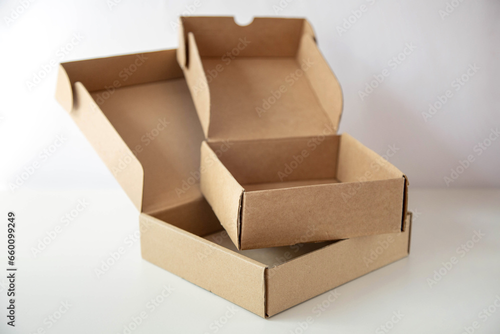 Two open empty cardboard boxes are on a bright background. Two open empty cardboard boxes are on a bright background.