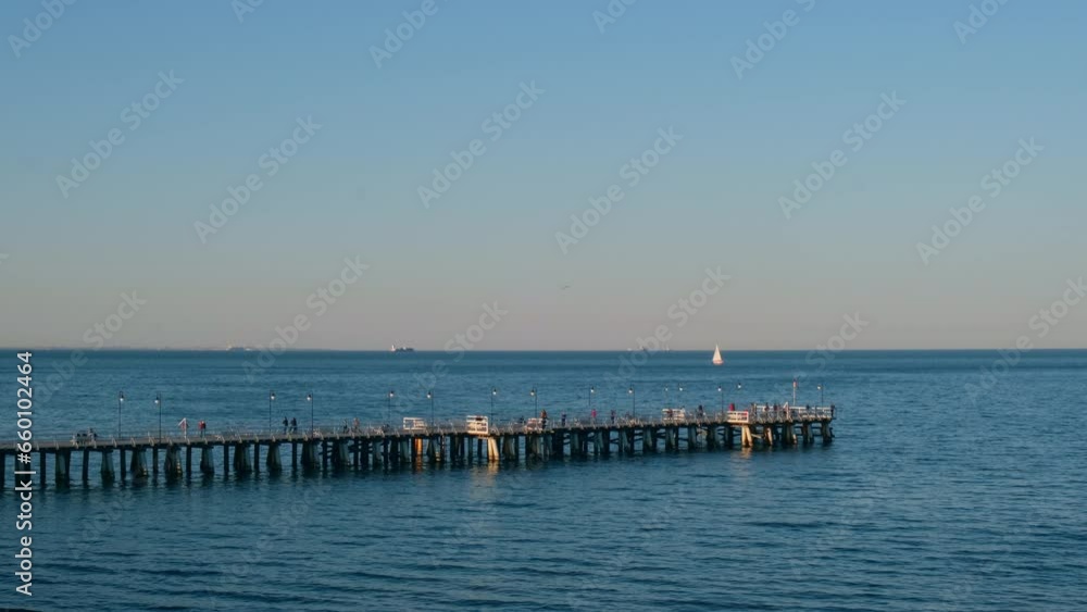 Storm sea waves empty wooden pier in dramatic blue sky background. Seascape with running splashing sea waves. Sandy beach vacation getaway in Gdansk Poland. Copy space for your text Storm sea waves empty wooden pier in dramatic blue sky background. Seascape with running splashing sea waves. Sandy beach vacation getaway in Gdansk Poland. Copy space for your text