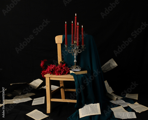 Romantic view with the candles, chandelier and a chair with black background