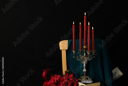 Red candles on the antique chandelier with black background