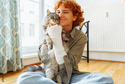 teenager with broken arm in cast and pet cat
