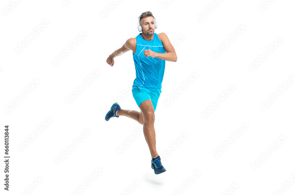 sport jogger listening to music in headphones. The jogger ran at sport training isolated on white. In a morning sport workout jogger run in studio. The jogger stretched legs before running