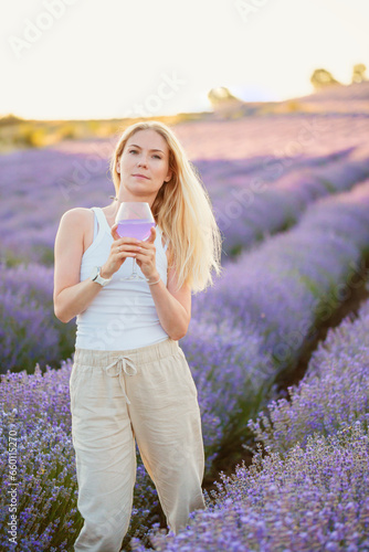 Wallpaper Mural Lavender field. Beautiful woman with blond hair walking between rows of lavender flowers with glass of summer refreshing cocktail, relaxing, resting, enjoying nature. Mental health concept Torontodigital.ca