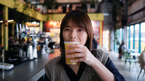 Asian Woman Enjoys Juice Gazing at the Camera