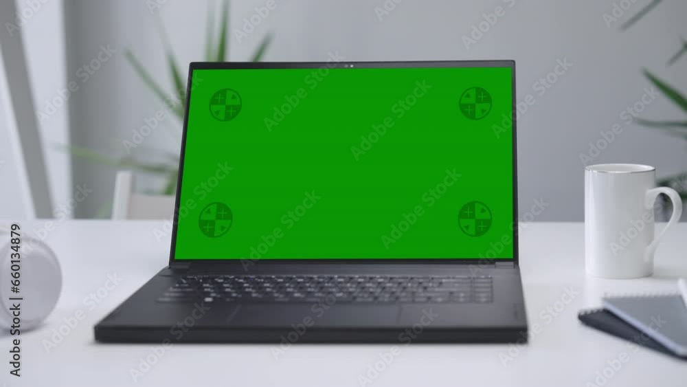 Modern Laptop Computer on White Desk with Blank Empty Green Mockup Screen Modern Laptop Computer on White Desk with Blank Empty Green Mockup Screen