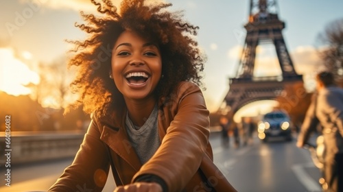 Happy young black woman riding bicycle in Paris. © visoot