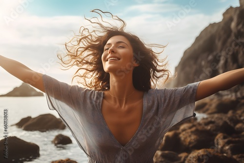 A woman embracing the power of the ocean with outstretched arms