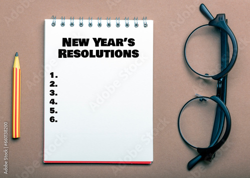 NEW YEAR'S RESOLUTIONS words in an office notebook.