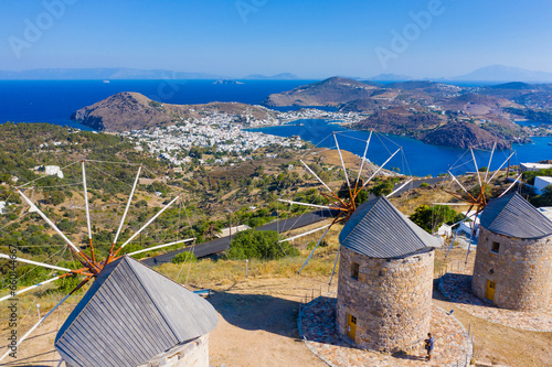 Fototapeta Naklejka Na Ścianę i Meble -  The three windmills of Chora and iconic Monastery of Saint John the Theologian in chora of Patmos island, Dodecanese, Greece