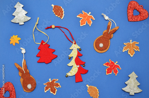 handmade Christmas tree decorations made of wood and felt on a blue background
