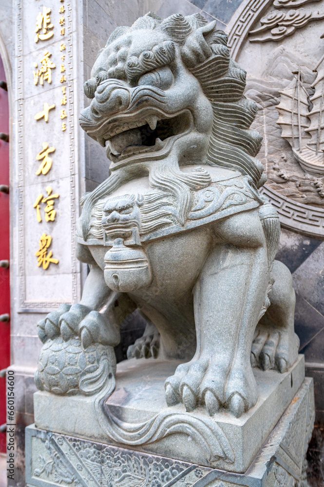 stone lion statue in front of a temple