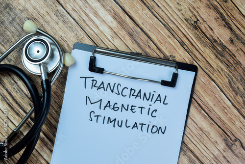 Concept of Transcranial Magnetic Stimulation write on paperwork isolated on Wooden Table. photo