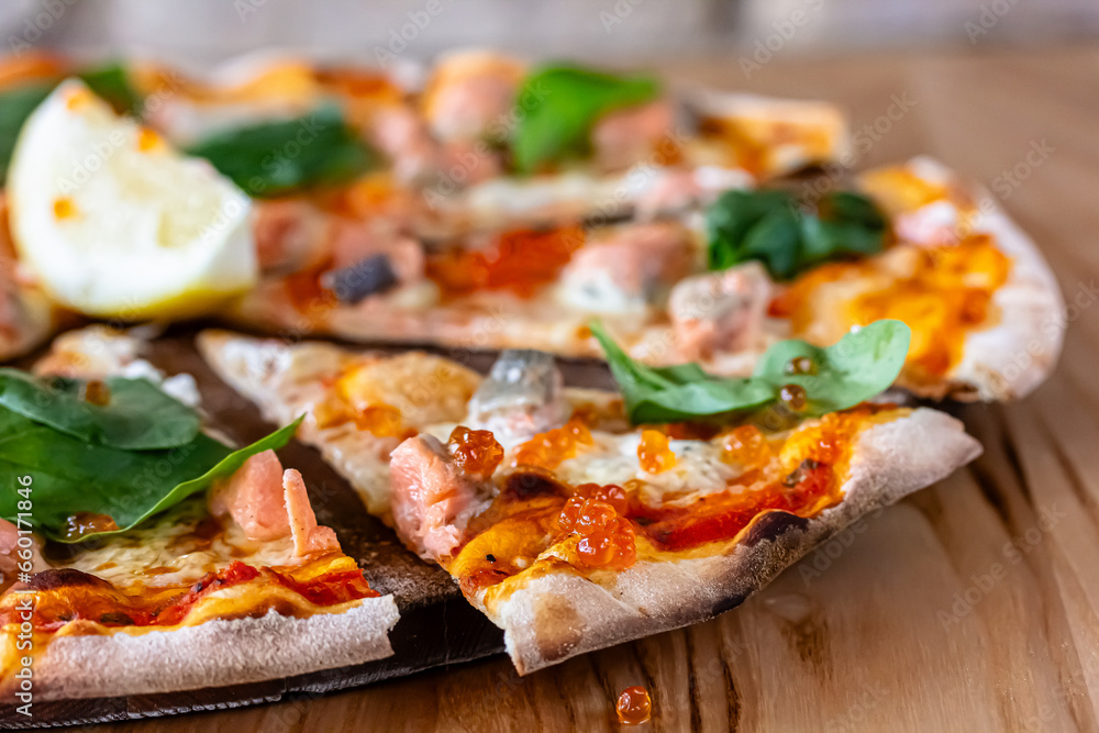 Delicious hot pizza with salmon, red caviar, tomatoes and aragula ready to eat. banner, menu, recipe place for text, top view. Delicious hot pizza with salmon, red caviar, tomatoes and aragula ready to eat. banner, menu, recipe place for text, top view.