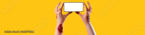 Zombie hands holding mobile...