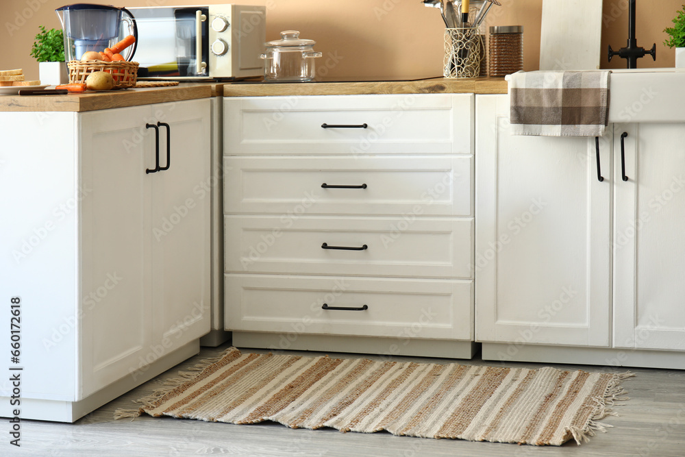 Stylish rug on floor in modern kitchen Stylish rug on floor in modern kitchen