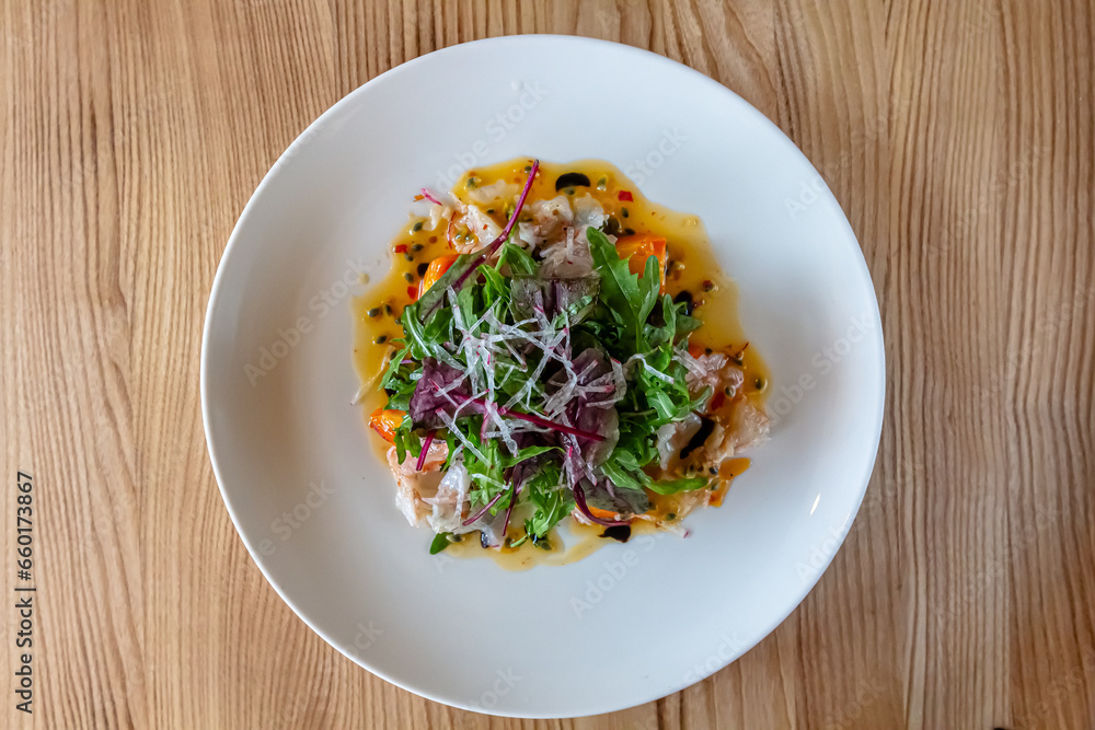 Fresh crispy salad with vegetables and seafood (shrimps) in a white plate on a light background. Healthy food concept. Fresh crispy salad with vegetables and seafood (shrimps) in a white plate on a light background. Healthy food concept.