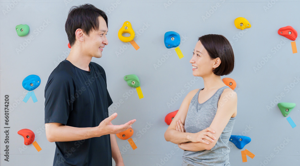 ボルダリングジムで雑談をするカップル