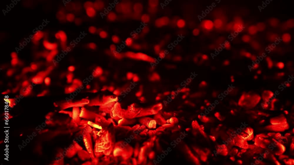 Hot red embers left from the campfire. Light smoke raises up from the charcoal. Close up. Hot red embers left from the campfire. Light smoke raises up from the charcoal. Close up.