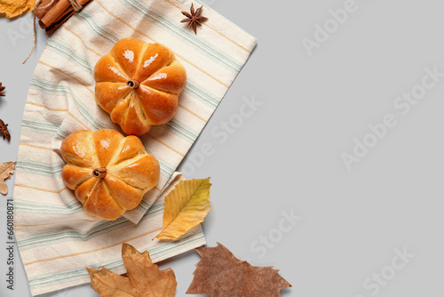 Tasty pumpkin shaped buns on grey background