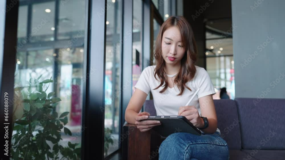 Young adult Asian student online learning talking on online chat meeting using tablet computer in coffee shop or office,Young businesswoman working in a coffee shop Young adult Asian student online learning talking on online chat meeting using tablet computer in coffee shop or office,Young businesswoman working in a coffee shop