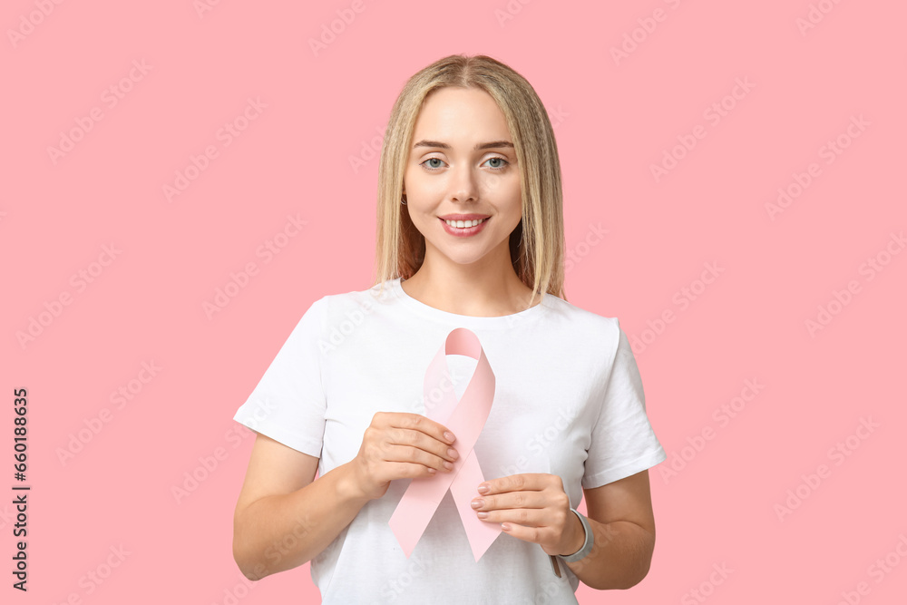 Young woman with ribbon on pink background. Breast cancer awareness concept Young woman with ribbon on pink background. Breast cancer awareness concept