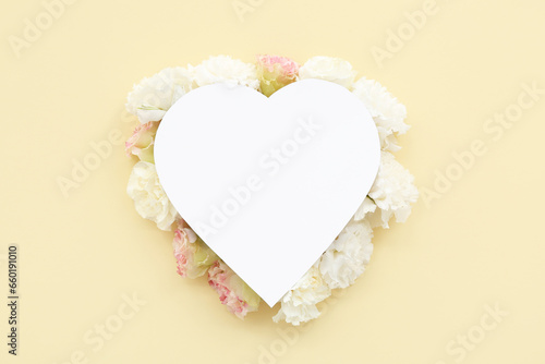 Paper heart with carnation flowers on yellow background. National Sweetest Day