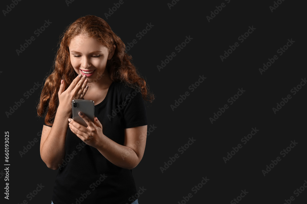 Beautiful young woman with mobile phone on dark background. Black Friday sale Beautiful young woman with mobile phone on dark background. Black Friday sale