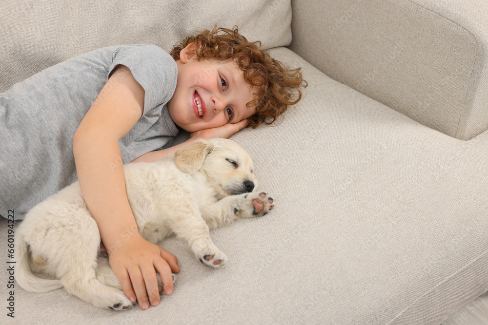 Little boy hugging cute puppy on couch. Space for text Little boy hugging cute puppy on couch. Space for text