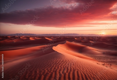 A vast desert landscape with rolling sand dunes under a crimson sunset