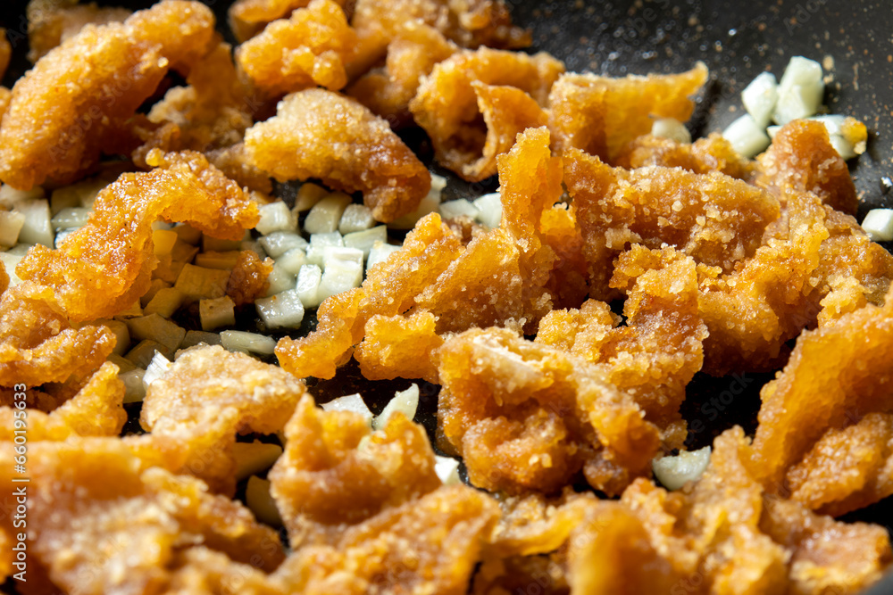 残り物揚げ物リメイクイメージ。鶏皮の唐揚げをにんにくと炒める調理シーン。
残り物揚げ物リメイクイメージ。鶏皮の唐揚げをにんにくと炒める調理シーン。