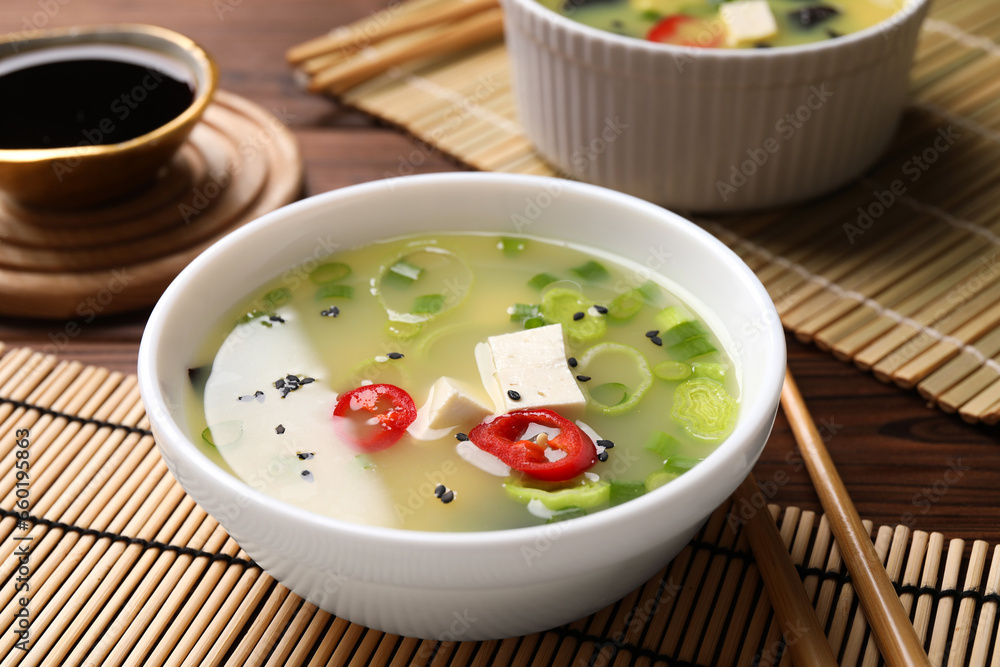 Bowl of delicious miso soup with tofu served on wooden table