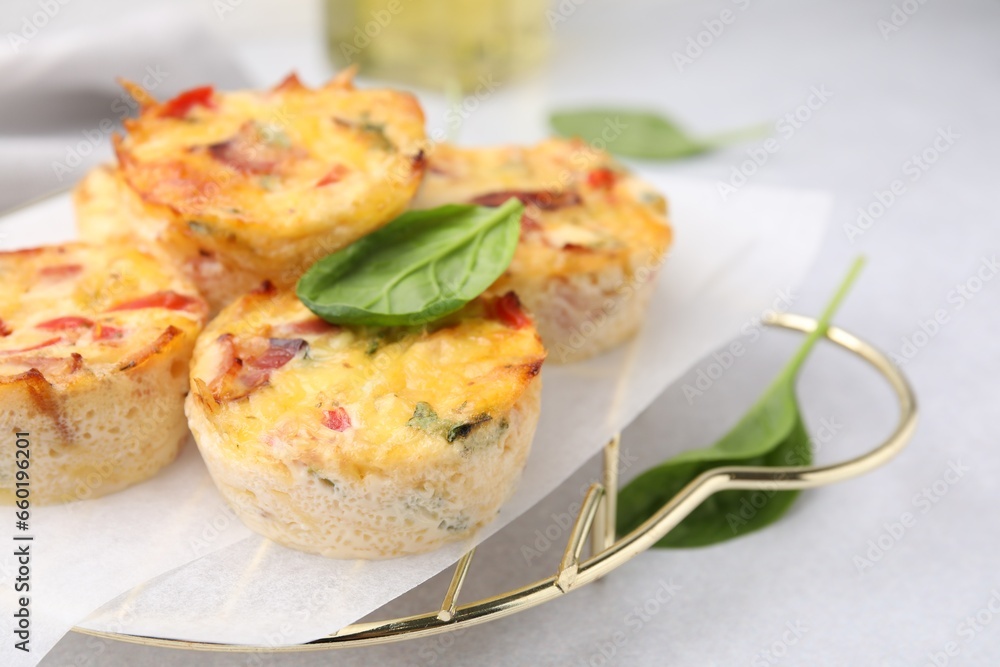 Freshly baked bacon and egg muffins with cheese on light gray table, closeup. Space for text