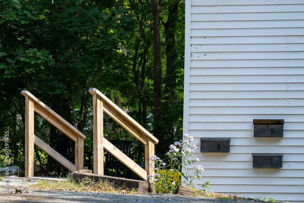 The exterior entrance to a three apartment building with three black