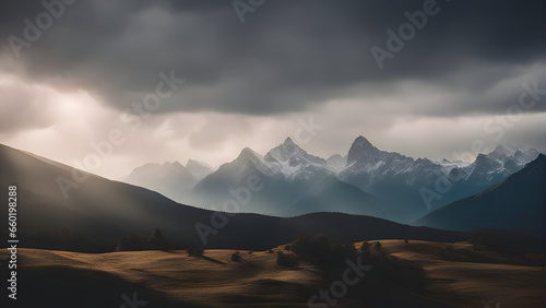 Mountain landscape with snow covered peaks in the clouds at dawn.