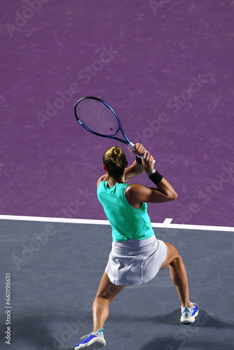 Female tennis player in action on the court at night, vertical © Teran