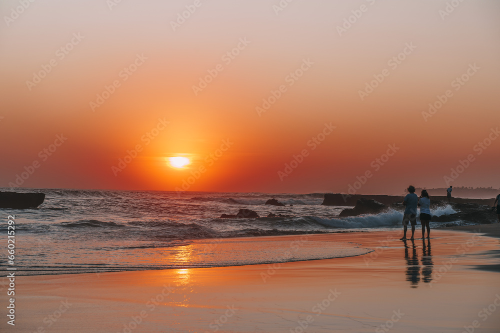 sunset in the Canggu beach,silhouette of unrecognizable couple