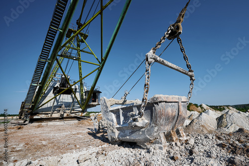 Empty bucket of modern dragline on ground at chalk quarry