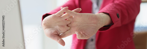 Fotografia Woman in pink jacket stretches arms after work on computer