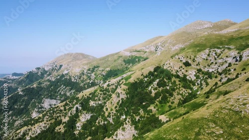 Slow aerial of beautiful mountain peaks and the edge of the forest at high altitude. photo