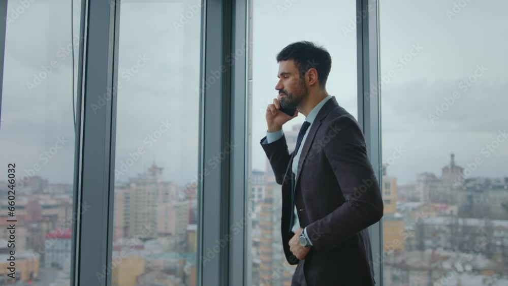 Businessman talking phone negotiations standing at office window. Business call Businessman talking phone negotiations standing at office window. Business call