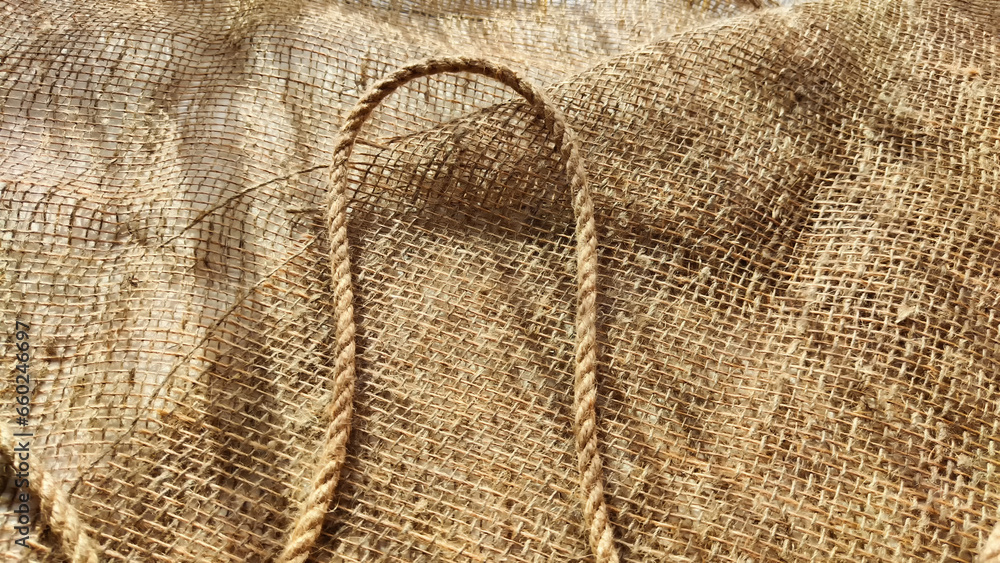 Burlap fabric, coarse jute weave, and thick burlap rope. Background, texture, pattern, and frame. Burlap fabric, coarse jute weave, and thick burlap rope. Background, texture, pattern, and frame.
