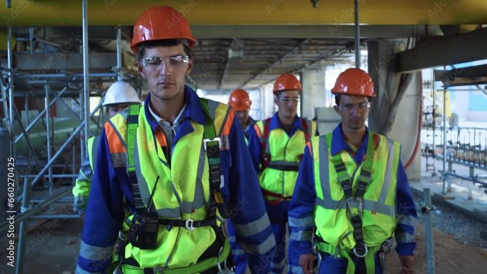 Team engineer metalworker in protective helmet uniform going refinery construction together Team engineer metalworker in protective helmet uniform going refinery construction together