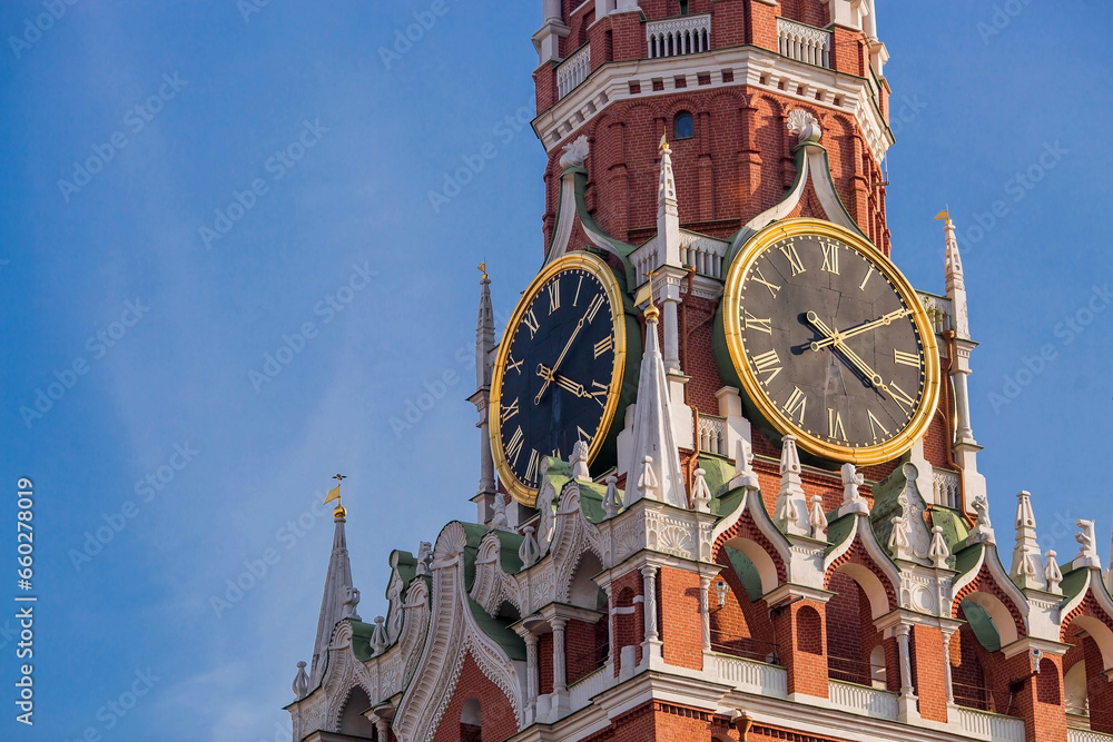MOSCOW, RUSSIA - SEPTEMBER 26, 2023: The Kremlin's Spasskaya Tower on Red Square on a sunny autumn evening against a bright blue sky. A large clock and chimes on the Spasskaya Tower.